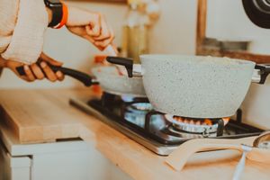 Close-up of a person cooking with cookware on a gas stove in a cozy Istanbul kitchen.